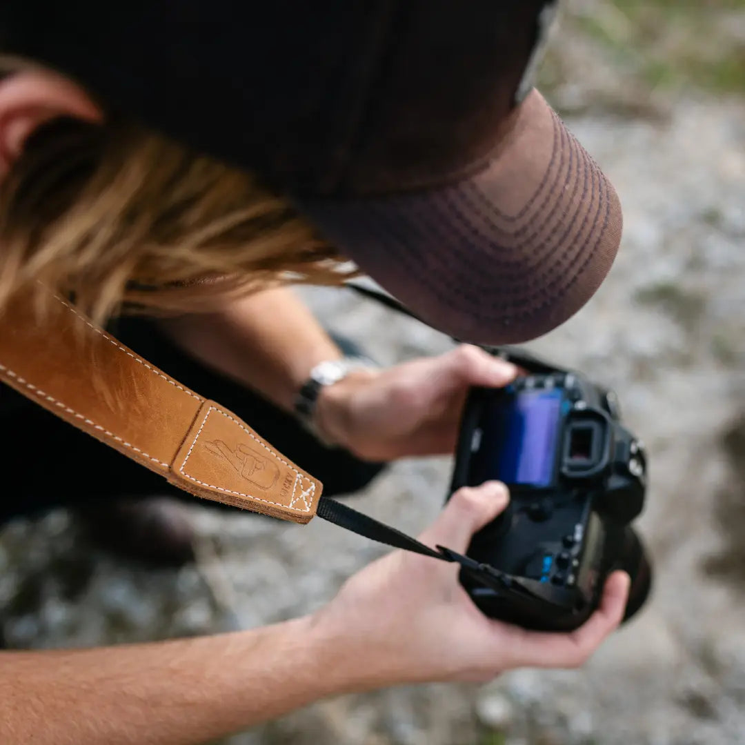 Photographer using camera with leather neck strap by lucky camera straps
