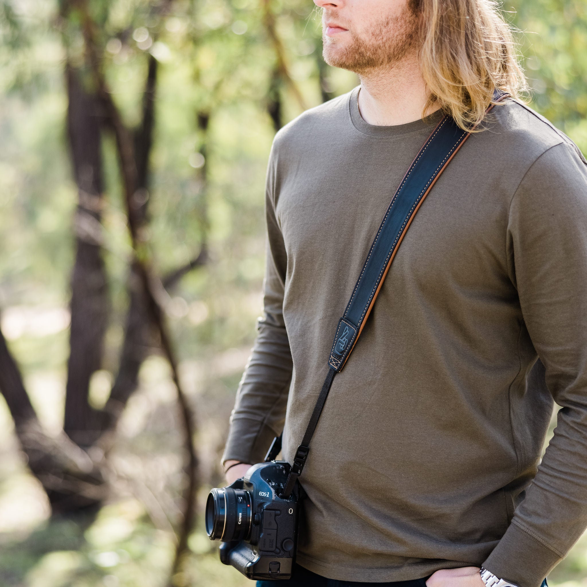 Photographer with leather lucky camera strap slung across body