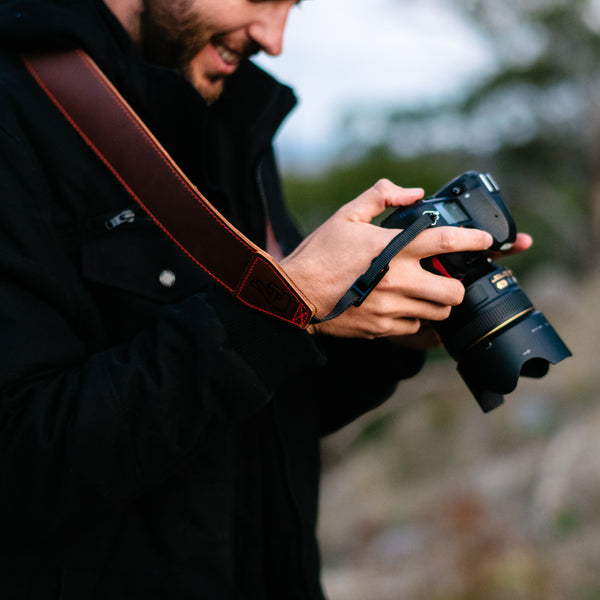 Photographer using leather camera strap which makes a great gift